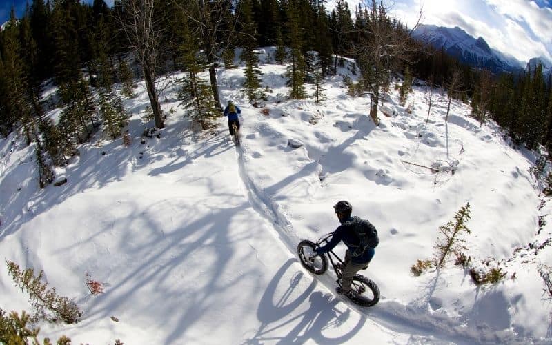 2 mens trailing with mtb on snow
