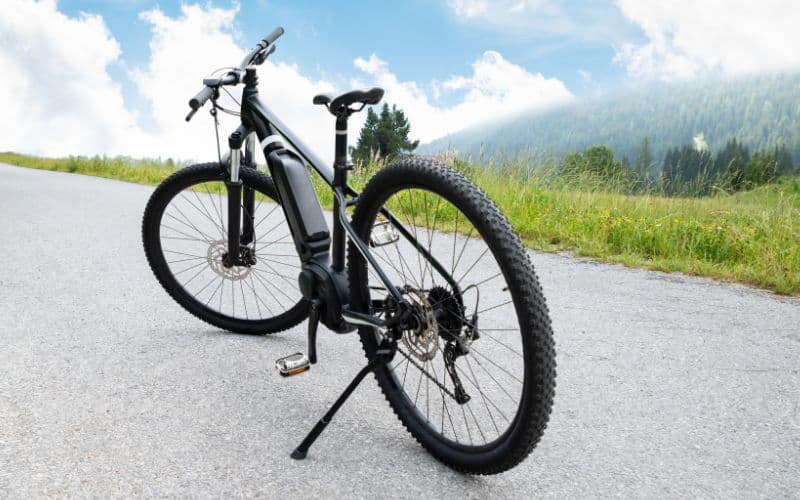 mountain bike with kickstand is placed on the road to a mountain